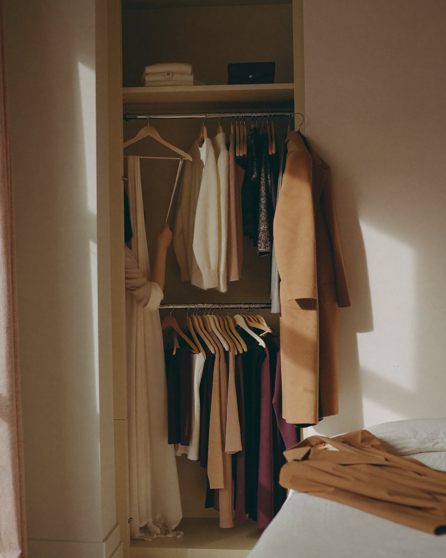Wardrobe after a detox: clothes hung by colour, from light to dark