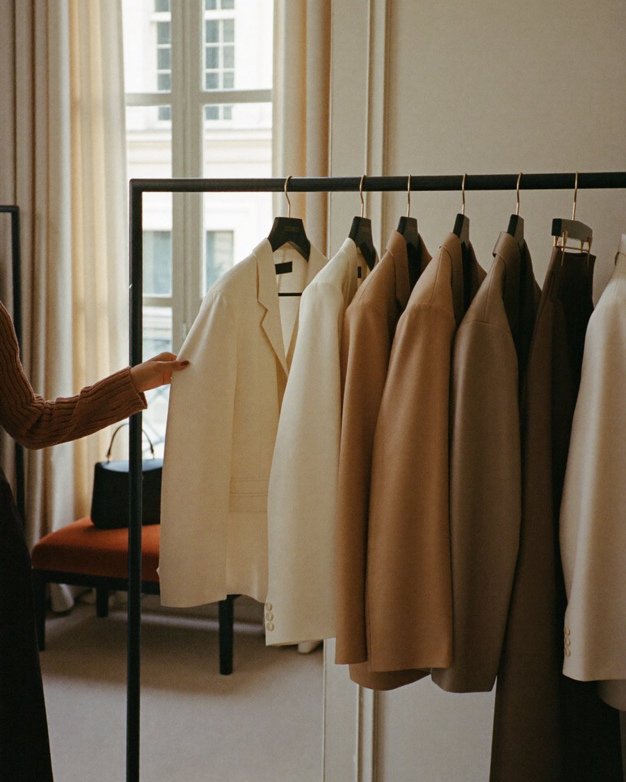 Rail of cream and camel blazers being browsed during a personal shopping session